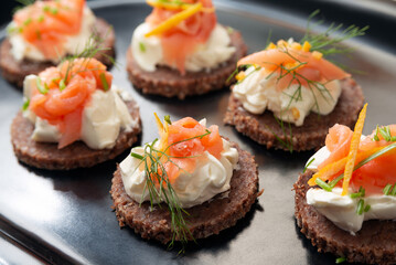 Vassoio con deliziose canapès condite con salmone affumicato e crema di formaggio, antipasto europeo