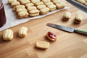 Filling Christmas cookies with strawberry marmalade