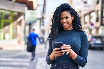 African american woman smiling confident using smartphone at street