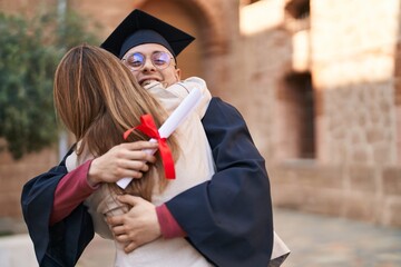 Man and woman mother and son hugging each other celebrating graduation at university