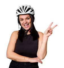 Young caucasian woman wearing a helemet isolated joyful and carefree showing a peace symbol with fingers.
