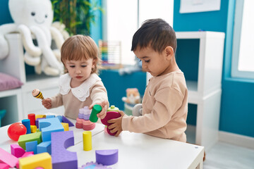 Two kids playing with construction blocks standing at kindergarten