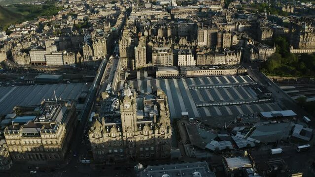 Rising aerial view of The Balmoral clock tower to reveal how large Edinburgh's downtown sector is.