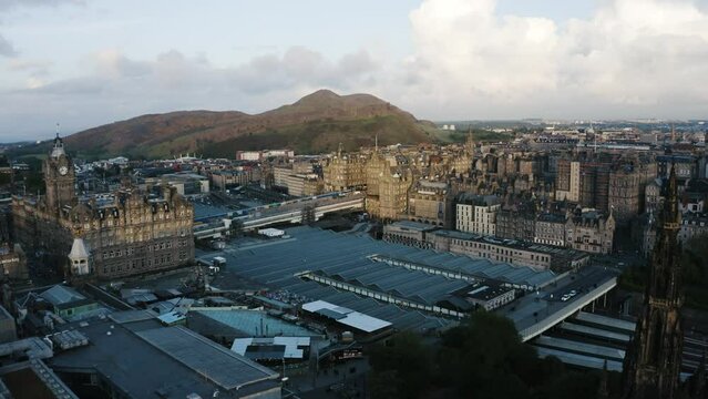 Aerial shot pushing over the Waverley Train Station and into Edinburgh's downtown buildings.
