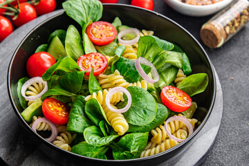pasta salad tomato, cucumber, green leaf mix salad, Fusilli healthy meal food snack on the table copy space food background rustic top view