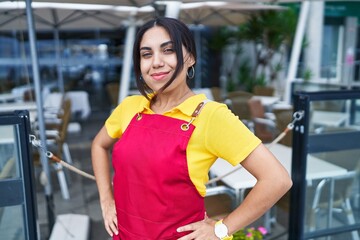 Young beautiful arab woman waitress smiling confident standing at coffee shop terrace