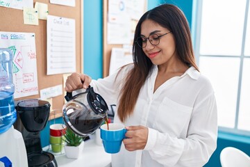 Young beautiful arab woman business worker pouring coffee on cup at office