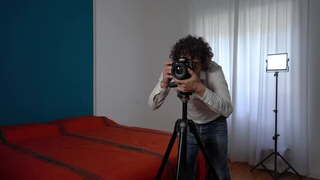 Italy, Milan - Real estate photographer man taking professional pictures and video of the bedroom for real estate agency - home staging to sell the house - renting a home for tourist  traveller 