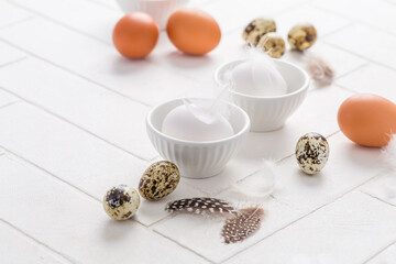 Obraz na płótnie Canvas Different eggs with feathers for Easter on white background