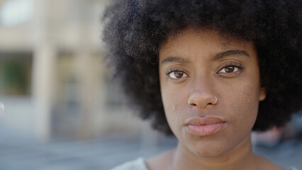 African american woman standing with serious expression at street © Krakenimages.com
