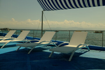Sunbed on Boat with stripe blue tent and background of sea, sky and Clouds at Lembongan Island, Bali -Indonesia