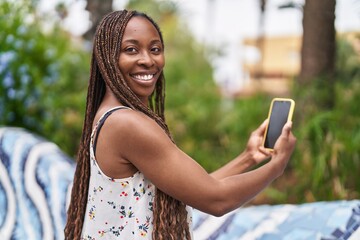 African american woman smiling confident using smartphone at park