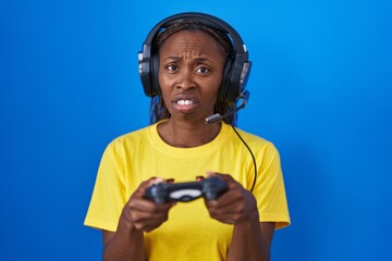 African american woman playing video games clueless and confused expression. doubt concept.