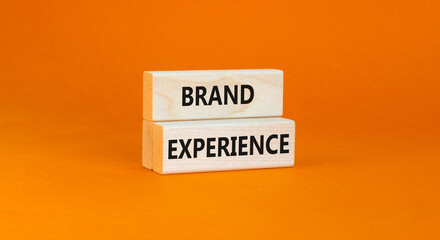 Brand experience symbol. Concept words Brand experience on wooden blocks. Beautiful orange table orange background. Business branding and brand experience concept. Copy space.