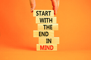 Start in end of mind symbol. Concept words Start with the end in mind on wooden blocks. Beautiful orange table orange background. Businessman hand. Business start in end of mind concept. Copy space. - obrazy, fototapety, plakaty