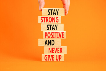 Never give up symbol. Concept words Stay strong stay positive never give up on wooden blocks. Beautiful orange background. Copy space. Businessman hand. Motivational business never give up concept. - obrazy, fototapety, plakaty