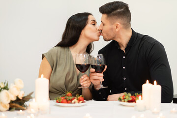 Attractive couple kissing while celebrating St. Valentines Day at home