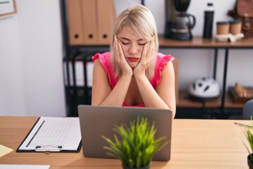 Young blonde woman business worker stressed using laptop at office