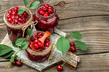 Jar of cherry jam and sour cherries. Berries cherry with syrup. Ripe ripe cherries. Sweet red...