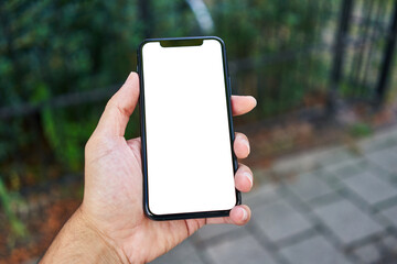 Man holding smartphone showing white blank screen at street