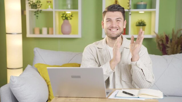 The man dealing with the laptop suddenly looks at the camera and starts clapping with a smile.
The man who gets things done from the laptop starts clapping happily towards the camera.
