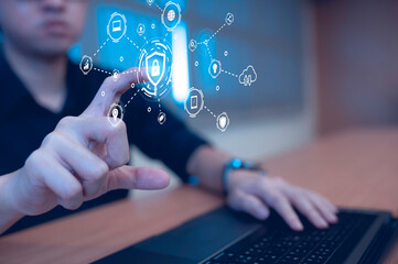 Businessman touch virtual screen on computer,Cyber secutiry concept,A shield protects the laptop from virus from the internet.