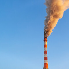 White thick smoke from the boiler room chimney. Smoke against the blue sky. Air pollution. Heating of the city. Industrial zone.
