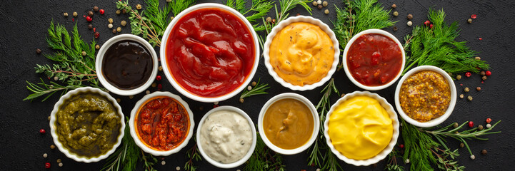 Different types of sauces in bowls with seasonings banner, rosemary and dill, thyme and and peppercorns, top view, copy space