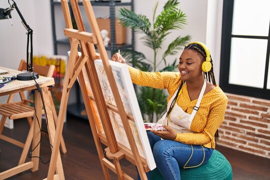 African american woman artist listening to music drawing at art studio