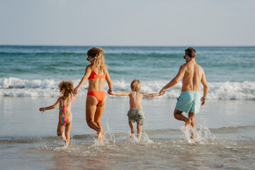 Happy family with little kids enjoying time at sea in exotic country.