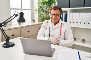 Senior doctor man working on online appointment with hand on stomach because indigestion, painful...