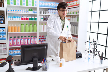 Non binary man pharmacist putting products on shopping bag at pharmacy