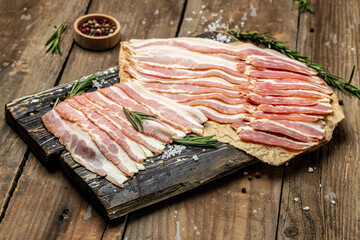 Fresh pork bacon lard raw meat on a wooden board. Keto diet food ingredients. banner, menu, recipe place for text, top view