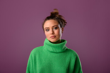 Young woman posing in sweater during studio shooting.