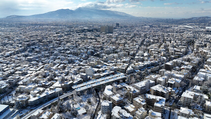 Aerial drone photo of main train station of Marousi centre and district covered in snow as seen at...