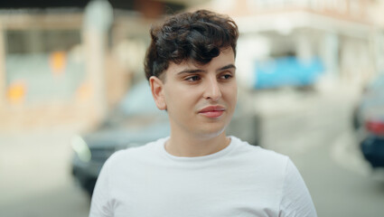 Non binary man looking to the side with serious expression at street