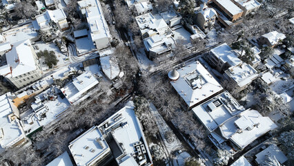Aerial drone photo of main commercial centre of Kifisia district covered in snow during winter...