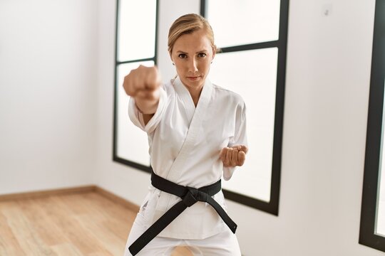 Young caucasian woman training karate at sport center