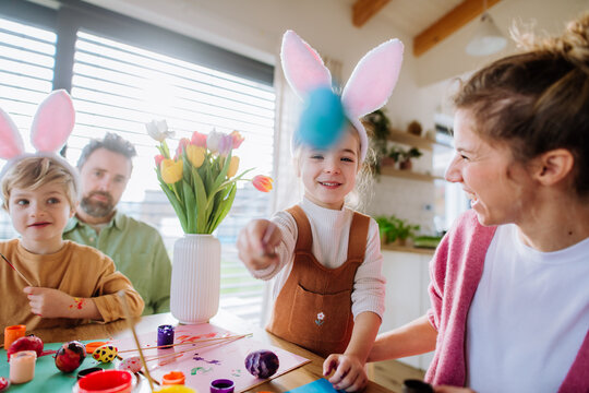 Happy Family With Little Kids Decorating Easter Eggs.