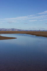 Puddle with sand and a mountain behind