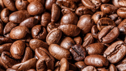 Freshly roasted coffee beans background.Dark roasted coffee beans with scoop on wooden background.
