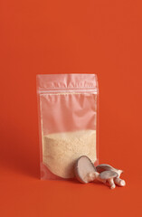mushroom flour in bag package and oyster mushrooms on the orange background with copy space