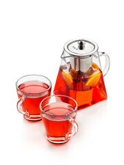 Red fruit tea with oranges, kiwi, strawberries in a glass teapot and cups. On a white background , isolate