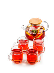 Red fruit tea with oranges, kiwi, strawberries in a glass teapot and cups. On a white background , isolate