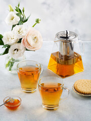 Green tea in a glass teapot and cups. On a white background. Tea concept.