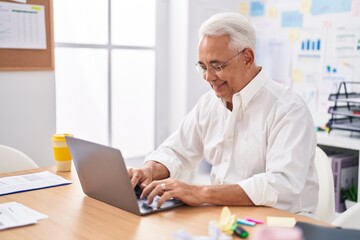 Middle age grey-haired man business worker using laptop working at office