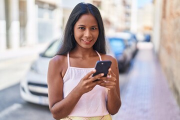 Young beautiful woman smiling confident using smartphone at street