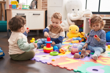 Group of kids playing with hoops toys sitting on floor at kindergarten