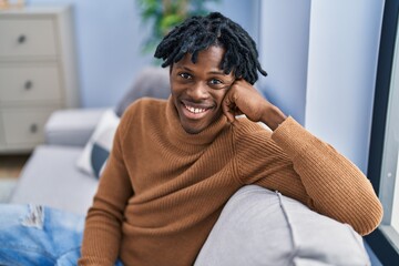 African american man smiling confident sitting on sofa at home