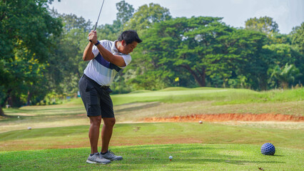 Golfer playing golf in the evening golf course